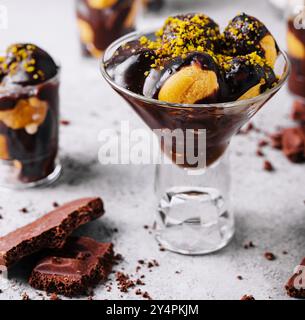 Cucina francese, gustosi profiteroles di dessert con cioccolata calda Foto Stock