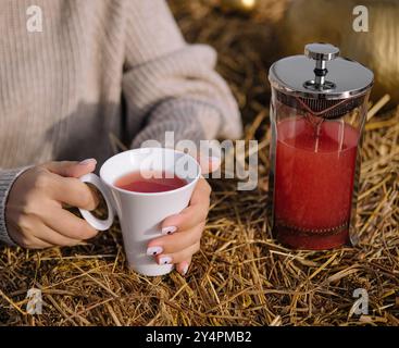 Una donna tiene una tazza di tè da vicino Foto Stock