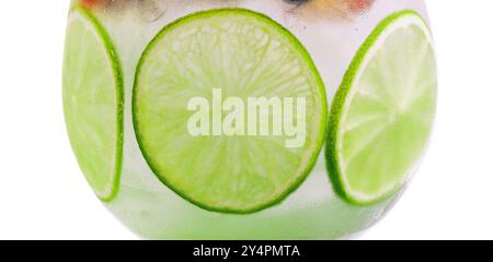 Bere con fette di lime e menta in un bicchiere di vino Foto Stock