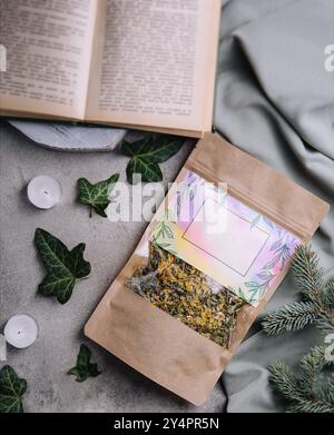 Foglie di tè secco e fresco con libro Foto Stock