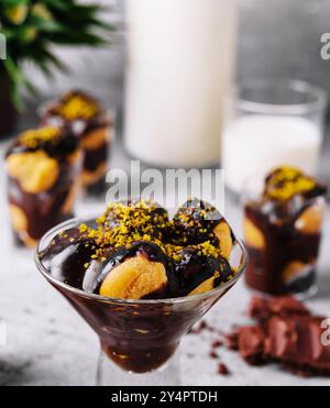 Cucina francese, gustosi profiteroles di dessert con cioccolata calda Foto Stock