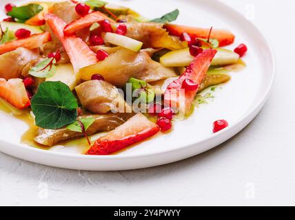 pesce con fragole, pere e melograni in salsa Foto Stock