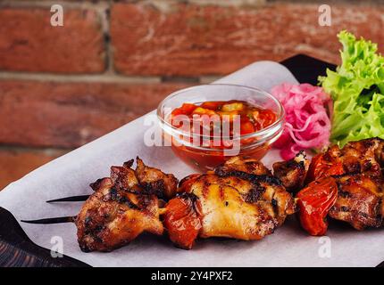 Kebab di pollo con salsa di pomodori su tavola Foto Stock