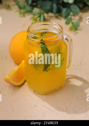 Limonata con fette di arance fresche e menta in una caraffa di vetro Foto Stock