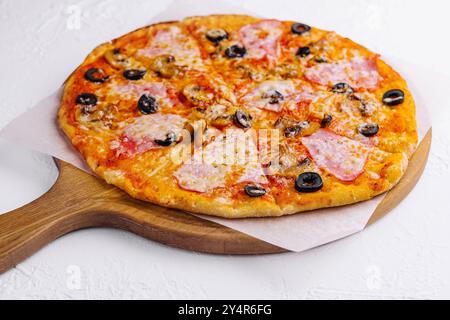 pizza con prosciutto e funghi su sfondo chiaro Foto Stock