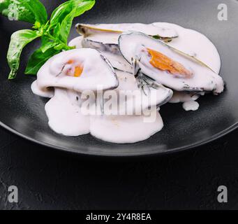 cozze in salsa cremosa di formaggio blu e basilico Foto Stock