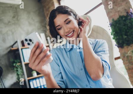 Foto di positivo buon umore signora specialista camicia vestito registrazione video gadget moderno al chiuso officina di lavoro Foto Stock