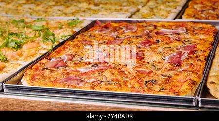 Gustose pizze quadrate su vassoi di metallo Foto Stock