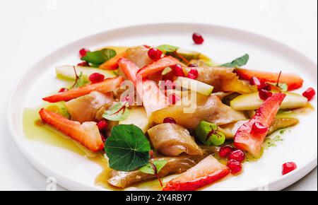 pesce con fragole, pere e melograni in salsa Foto Stock