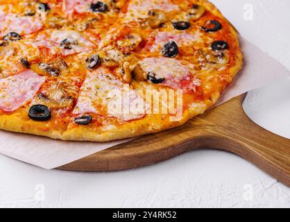 pizza con prosciutto e funghi su sfondo chiaro Foto Stock