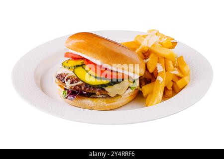 Succoso cheeseburger di manzo con condimenti freschi e un lato di patatine fritte, servito su un piatto bianco Foto Stock