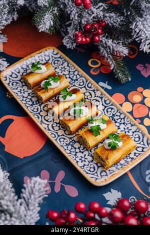 Elegante servizio di frittelle dolci condite con panna e prezzemolo su un piatto decorativo, sfondo festoso Foto Stock