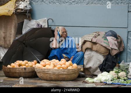 Mumbai, Maharashtra / India - 7 giugno 2008: Una vecchia donna che vende frutta e verdura per strada nella stagione dei monsoni. Foto Stock