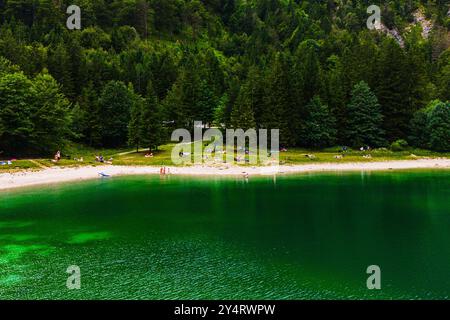 LAGO DEL PREDIL, ITALIA – 23 LUGLIO 2024: Vista panoramica del Lago del Predil, un tranquillo lago alpino circondato da aspre montagne che riflettono l'incontaminato Foto Stock