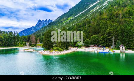 LAGO DEL PREDIL, ITALIA – 23 LUGLIO 2024: Vista panoramica del Lago del Predil, un tranquillo lago alpino circondato da aspre montagne che riflettono l'incontaminato Foto Stock