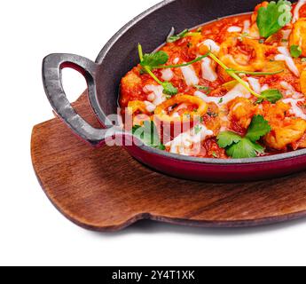 Appetitosi frutti di mare mescolati alle erbe in una padella di ghisa su un asse di legno isolato sul bianco Foto Stock