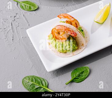 Elegante disposizione di antipasti di gamberi e un piatto di formaggi con noci e frutta su un tavolo moderno Foto Stock