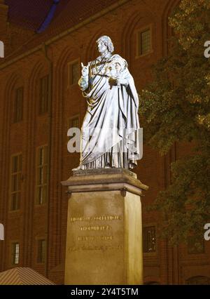 Monumento a Nicolaus Copernico nella città medievale vecchia di Thorn, illuminata di sera. Il centro storico della città di Torun è un'UNESCO World Her Foto Stock