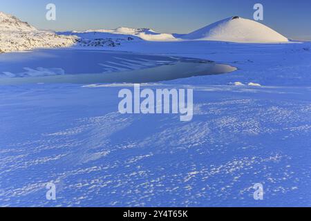 Luce mattutina su un campo di lava innevato, lago, cratere vulcanico, neve, inverno, Berserkjahraun, Snaefellsnes, Vesturland, Islanda, Europa Foto Stock