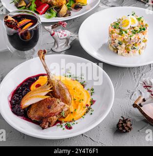 Vivace ambiente da tavolo per le vacanze con succulente vista dall'alto dell'anatra arrosto, dell'insalata e del VIN brulé Foto Stock