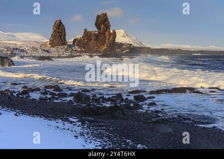 Rocce e surf sulla costa, luce notturna, sole, neve, inverno, Arnarstapi, Snaefellsnes, Vesturland, Islanda, Europa Foto Stock