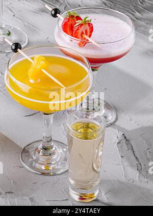 Varietà di cocktail rinfrescanti con decorazioni disposte su un tavolo con vista Foto Stock