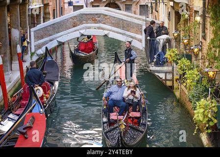 I turisti che prendono la gondola, la tradizionale barca veneziana, sul canale di Venezia, Italia, Europa Foto Stock