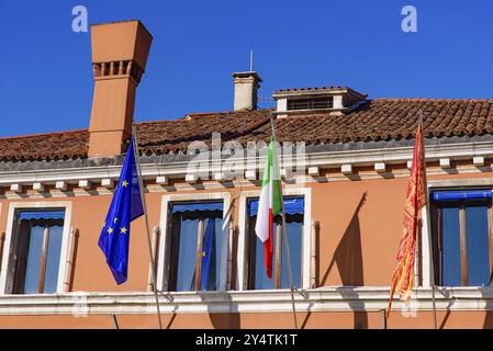 Un edificio con le bandiere dell'Unione europea, dell'Italia e di Venezia, dell'Europa Foto Stock