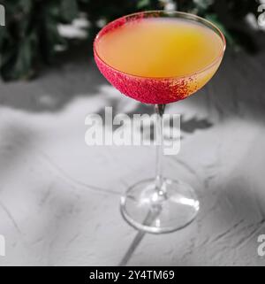 Elegante bicchiere da cocktail con un vivace bordo di zucchero, presentato su uno sfondo elegante e testurizzato Foto Stock