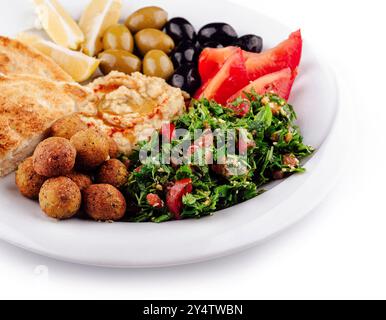 Piatto di deliziosi piatti mediorientali con pane pita, falafel, hummus, tabbouleh, olive e pomodori Foto Stock