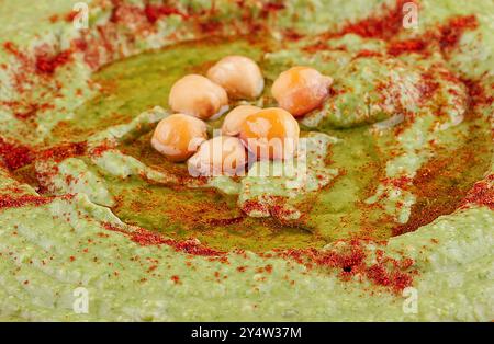 Hummus di pisello verde delizioso e salutare con olio d'oliva e paprika Foto Stock