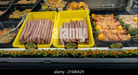 Salsiccia e salsiccia con erbe aromatiche, spiedini di pollo marinati in vendita presso un mercato di Arcachon, Francia. Foto Stock