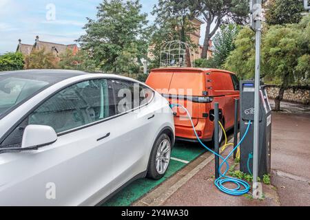 Un'auto Tesla e una Volkswagen ID Buzz in una stazione di ricarica di Arcachon, Francia. Foto Stock