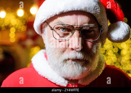 Buon Natale e felice anno nuovo. Ritratto ravvicinato di Babbo Natale serio in occhiali. Buone vecchie tradizioni. Vacanze in famiglia. Uomo di Natale a Babbo Natale Foto Stock