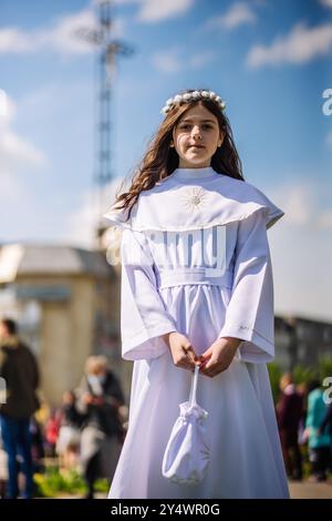 Lida, Bielorussia - 15 giugno 2021: Giovane ragazza che posa indossando il primo vestito da comunione con le perle del rosario Foto Stock