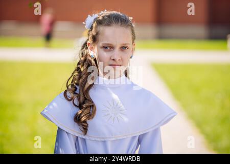 Lida, Bielorussia - 15 giugno 2021: Giovane ragazza che indossa un vestito bianco in posa per la prima celebrazione della comunione Foto Stock