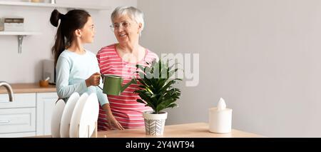 Bambina con la sua nonna annaffiatura casalinga in cucina Foto Stock