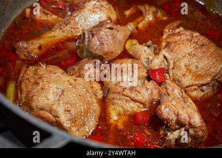 Una pentola di pollo allo stufato marrone, un classico piatto giamaicano Foto Stock