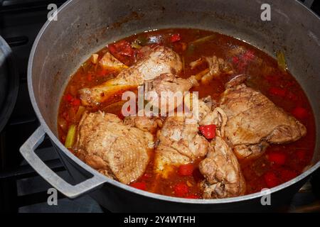 Una pentola di pollo allo stufato marrone, un classico piatto giamaicano Foto Stock