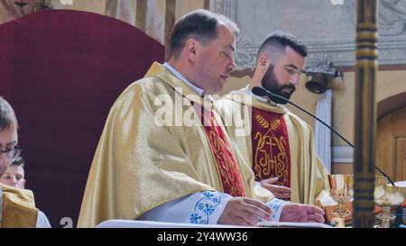 Lida, Bielorussia - 15 giugno 2021: Sacerdoti che celebrano la Santa messa sull'altare della chiesa Foto Stock