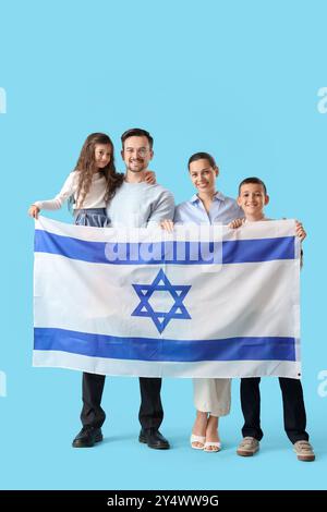 Felice famiglia ebraica con bandiera di Israele su sfondo blu Foto Stock