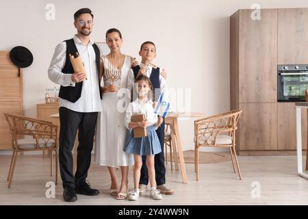 Felice famiglia ebraica con bandiera di Israele e libri a casa Foto Stock