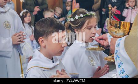 Lida, Bielorussia - 15 giugno 2021: Bambini che ricevono la prima Santa comunione in chiesa Foto Stock