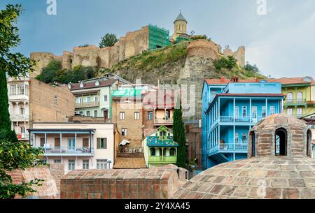 Centro storico della vecchia Tbilisi, Georgia. Antico quartiere di Abanotubani, bagni di zolfo, tetto a forma di cupola, balconi in legno intagliato, fortezza di Narikala Foto Stock