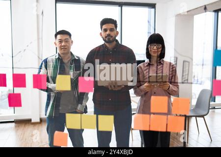 Collaborazione tra team utilizzando appunti adesivi negli uffici moderni Foto Stock