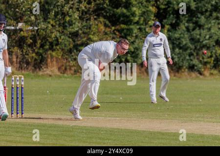 Il club di cricket Newton Aycliffe ha ospitato il club di cricket di Middlesborough in un sabato pomeriggio soleggiato. Bowler tira una faccia mentre lascia andare la palla Foto Stock