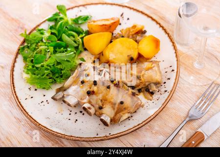 Costolette di maiale con patate bollite e foglie di insalata fresca Foto Stock