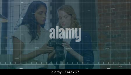 Analizzando le impostazioni della telecamera, due donne rispetto all'immagine dei dati del mercato azionario Foto Stock