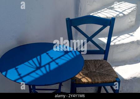 Colori, forme, ombre. Sedia tradizionale dipinta di blu, tavolo, scale dipinte di bianco. Forme provenienti da Megalochori, Santorini, Grecia Foto Stock