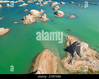 Una vista panoramica del geoparco di Wusute Yadan, con piccole formazioni rocciose sull'acqua nel Qinghai, in Cina, immagine di sfondo aerea Foto Stock